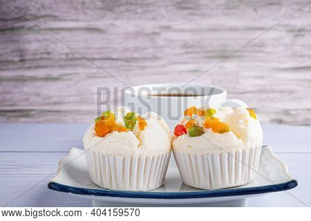 Side View Of Thai Steamed Cupcakes Topped With Dry Fruit On A Plate On A Blue Cloth With A White Cof