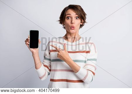 Photo Of Sweet Funny Young Woman Dressed Striped Pullover Holding Pointing Modern Device Isolated Gr