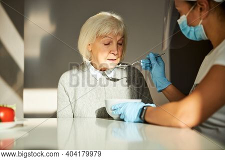 Pensioner Having Food Given By A Volunteer