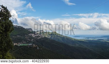 Panoramic View Of Landscape Of Supramonte Mountains With Green Soccer Field At Baunei Village, Limes