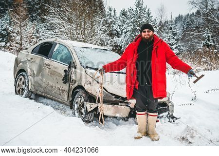 A Man With A Tow Rope Spreads His Hands, Smiles That He Is Unharmed After The Accident, Near The Car