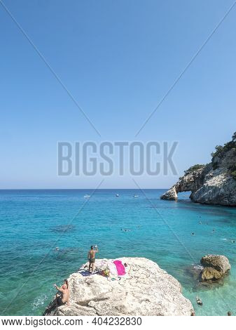Gulf Of Orosei, Sardinia, Italy, September 8, 2020: A View Of Yopung Woman Sunbathing At Cala Golori