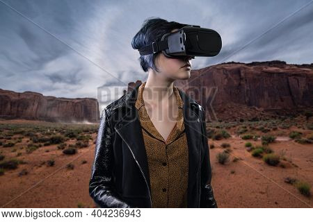Woman Wearing A Virtual Reality Headset In A Simulated Hiking Experience Through The Desert.  Vr Tou