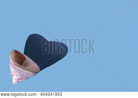 Top View Of Seashell With A Heart-shaped Shadow On Light-blue Background.