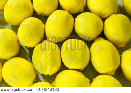 Fresh Ripe Lemons. Background From A Large Number Of Lemons Lying On The Table.