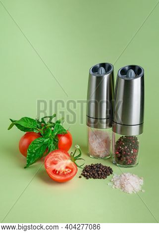 Electric Spice Mills. Nearby Salt, Pepper And Tomatoes. Green Background.electric Spice Mills. Nearb