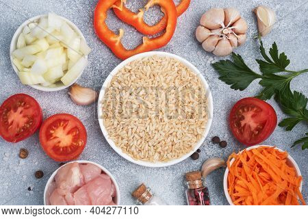 Raw Ingredients For Cooking Pilaf, Brown Rice And Chicken Fillet, Grated Carrots And Chopped Onions,