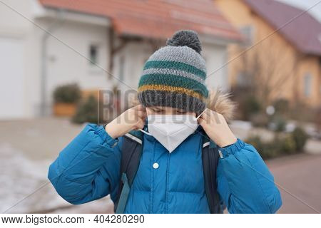 Kid Boy Wearing Ffp Medical Mask On The Way To School. Child Backpack Satchel. Schoolkid On Cold Aut