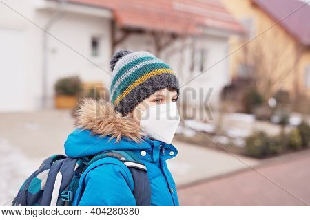 Kid Boy Wearing Ffp Medical Mask On The Way To School. Child Backpack Satchel. Schoolkid On Cold Aut