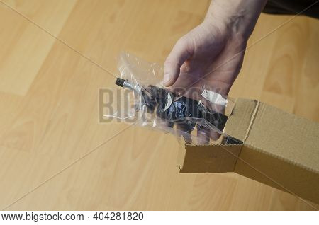 Continuous Light Photographic Equipment, Softbox. A Hand Pulls A New Black Softbox Tripod In Clear P