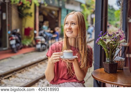 Young Woman Traveler Drinks Vietnamese Coffee With Egg Sitting By The Railway Paths Which Go Through