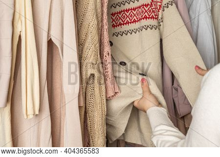 Woman Customer Checking The Material Choosing Woolen Sweater With Christmas Ornament From In Garment