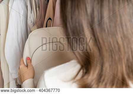 Woman Choosing  Small Leather Backpack, Clothes In Home Cupboard. Season Concept