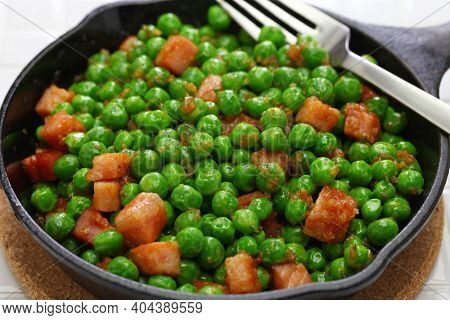 fresh green peas with ham in skillet