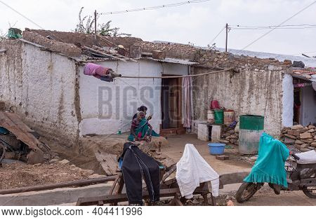 Lakundi, Karnataka, India - November 6, 2013: 2 Women Work Sitting In Front Of Poor White House With