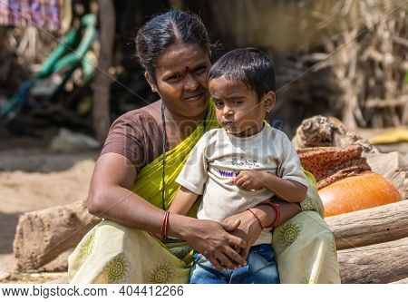 Lakundi, Karnataka, India - November 6, 2013: Closeup Of Sitting Mother Dressed In Brown Shirt And Y