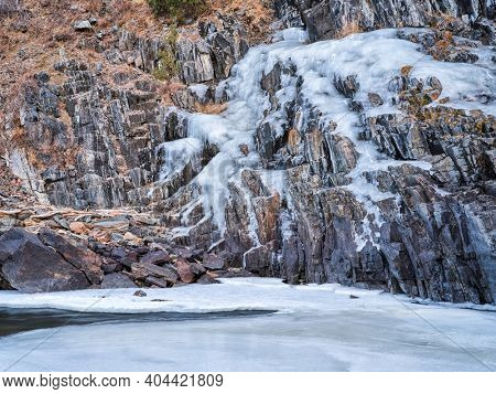 icy cliff on a canyon of mountain river in winter scenery - Poudre River at Little Narrow above Fort Collins, Colorado