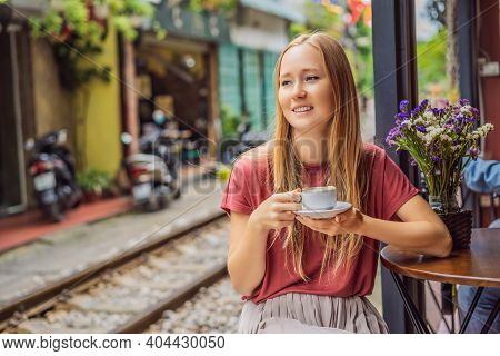 Young Woman Traveler Drinks Vietnamese Coffee With Egg Sitting By The Railway Paths Which Go Through