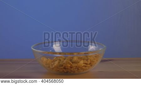 Crispy Yellow Corn Flakes Falling Into The Bowl In The Morning For A Delicious Breakfast. Action. Po