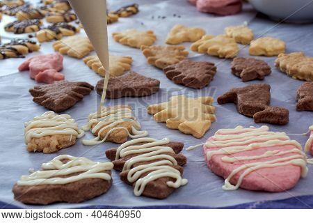 Pouring chocolate on just baked christmas cookies