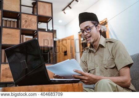 Man In Government Uniform Holding Papers While Working From Home Online