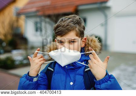 Kid Boy Wearing Ffp Medical Mask On The Way To School. Child Backpack Satchel. Schoolkid On Cold Aut