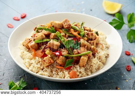Vegetarian Meat Free Mycoprotein Pieces Vegetable Stir Fry, Brown Rice Served In White Plate