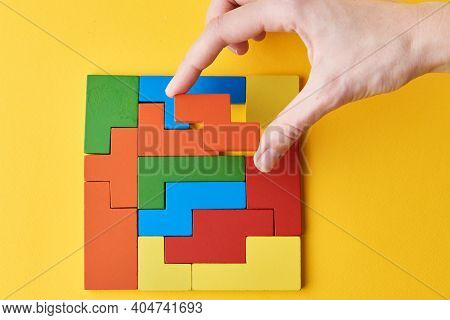 Logical Thinking And Finishing Task Concept. Woman Hand Adding Last Missing Wooden Block To Finish A