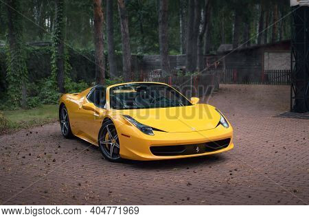 Kyiv, Ukraine - August 2020. Italian Super Car Ferrari 458 Spider In A Yellow Color In The Forest.