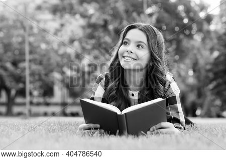 Let Your Creative Ability Investigate. Happy Child Read Book Lying On Green Grass. Reading Education