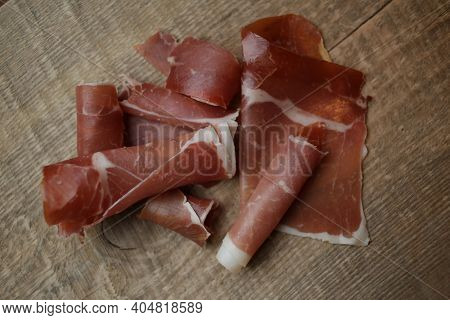 Sliced Jamon On A Wood Background. Parma Ham, Jamon On Wooden Background With Space For Text Top Vie