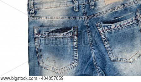 Waist And Back Pockets Part Of Slightly Tilted Light Blue Jeans With Faded White Spots. Isolated On 