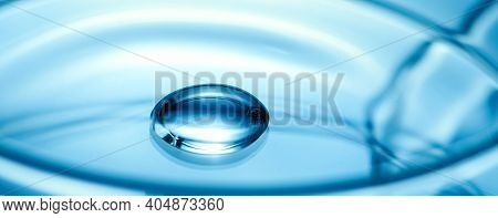 Clean Glass Petri Dish With Liquid Drop Inside Over Blue Light Background