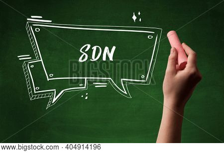 Hand drawing SDN abbreviation with white chalk on blackboard