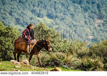 Azrou, Morocco - April 09, 2015. Young Cute Berber Girl Riding On The Donkey In Mountain