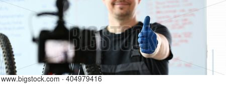 Happy Male Worker In Special Clothes Repairing A Bicycle And Shooting Video Content