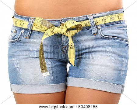 Beautiful young woman measuring her body with tape isolated on white