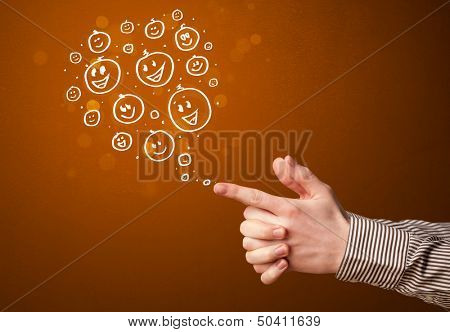 Group of happy hand drawed smiley faces coming out of gun shaped hands