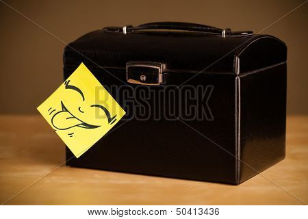 Drawn smiley face on a post-it note sticked on a jewelry box
