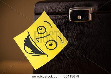 Drawn smiley face on a post-it note sticked on a jewelry box