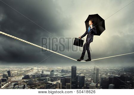 Image of pretty businessman balancing on rope