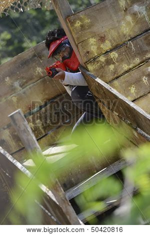 Young Children Playing Paintball In The Woods