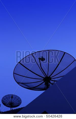 Silhouette of Satellite dish in blue sky at night