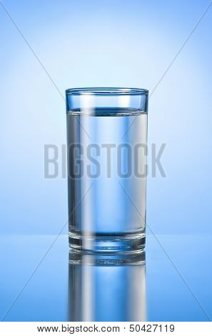 glass of pure water on blue glossy background