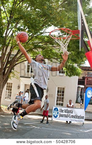 Man Attempts Slam Dunk During Outdoor Street Basketball Tournament