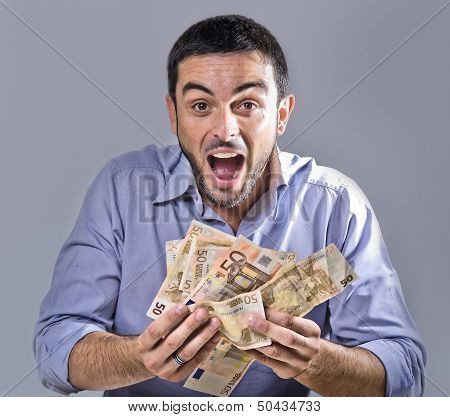 Exultant Young Man Holding Banknotes