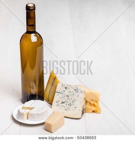 wine bottle and different kinds of cheese