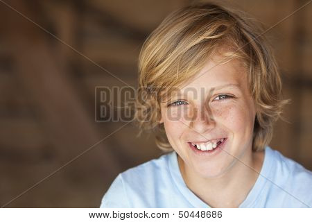 Young happy smiling blond boy child aged about twelve or early teenager  