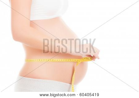 Pregnant woman measuring her belly isolated on white