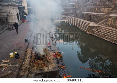KATHMANDU, NEPAL - DEC 20: During the cremation ceremony along the holy Bagmati River in Bhasmeshvar Ghat at Pashupatinath temple, Dec 20, 2013 in Kathmandu, Nepal.